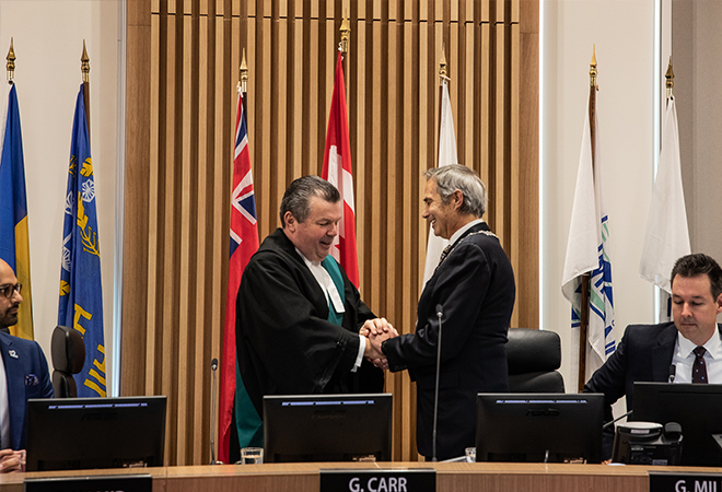 Halton Regional Chair Gary Carr receives the Official Chain of Office from Justice of the Peace Mark Curtis.