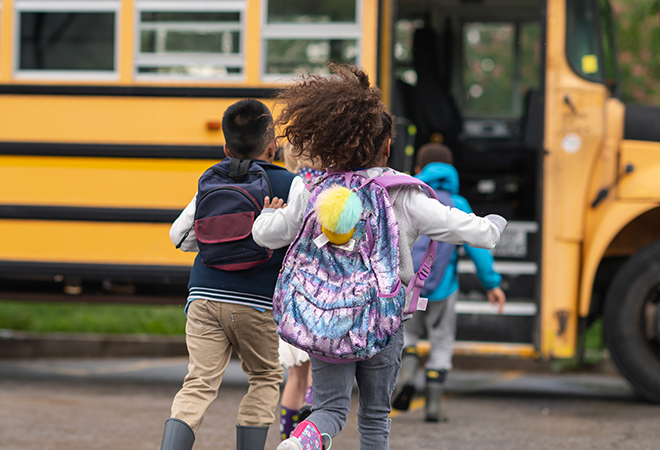Kids running towards school bus.