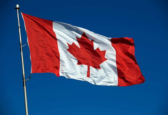 A Canadian flag flying against a clear blue sky. Happy Canada Day!