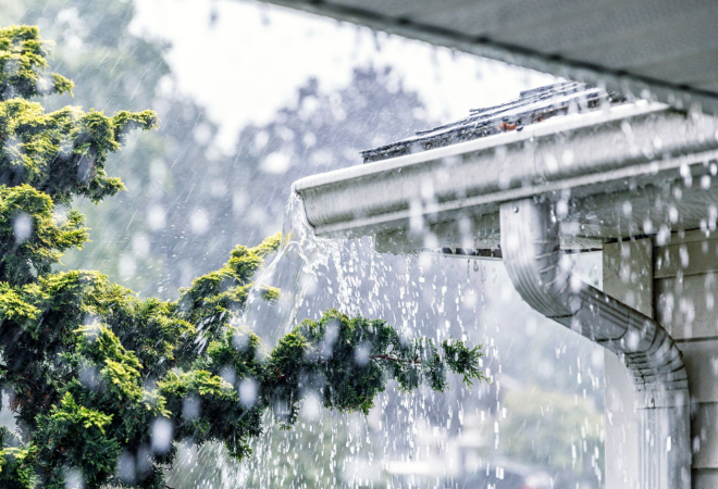 Rainy weather with water pouring off a roof.